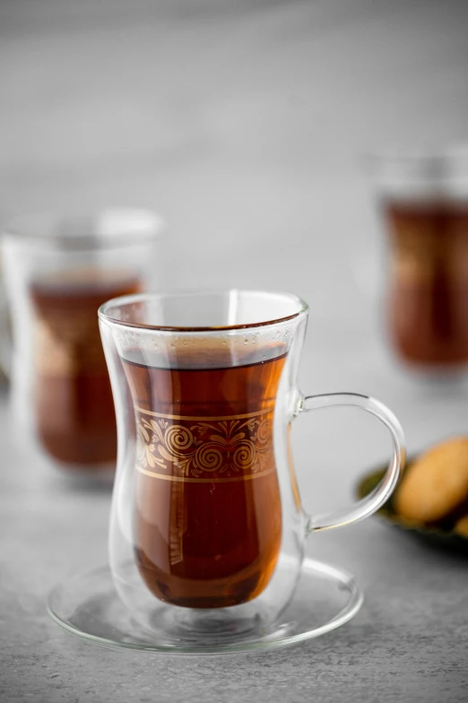 two glass cups are holding a liquid and bananas