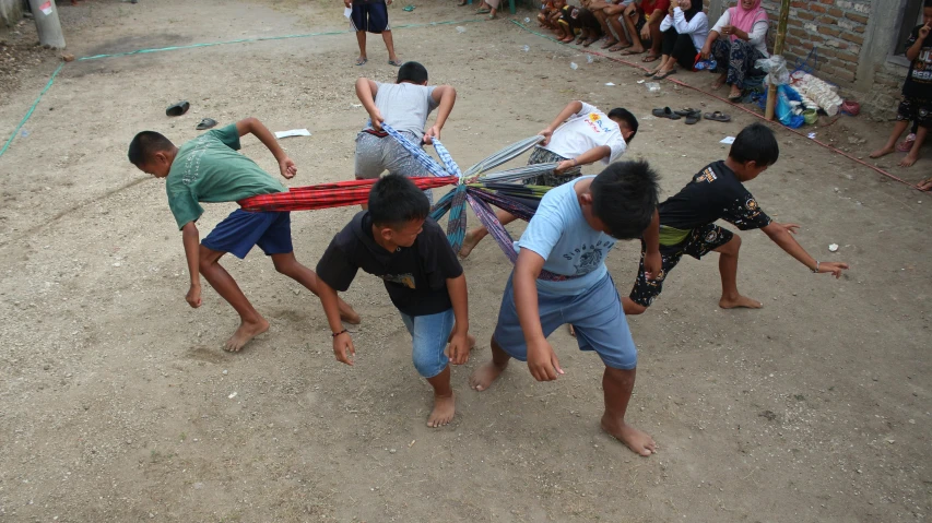 boys carry an object through the dirt with others