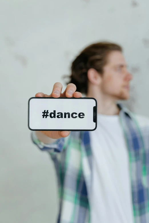 a man holding a sign with the word dance