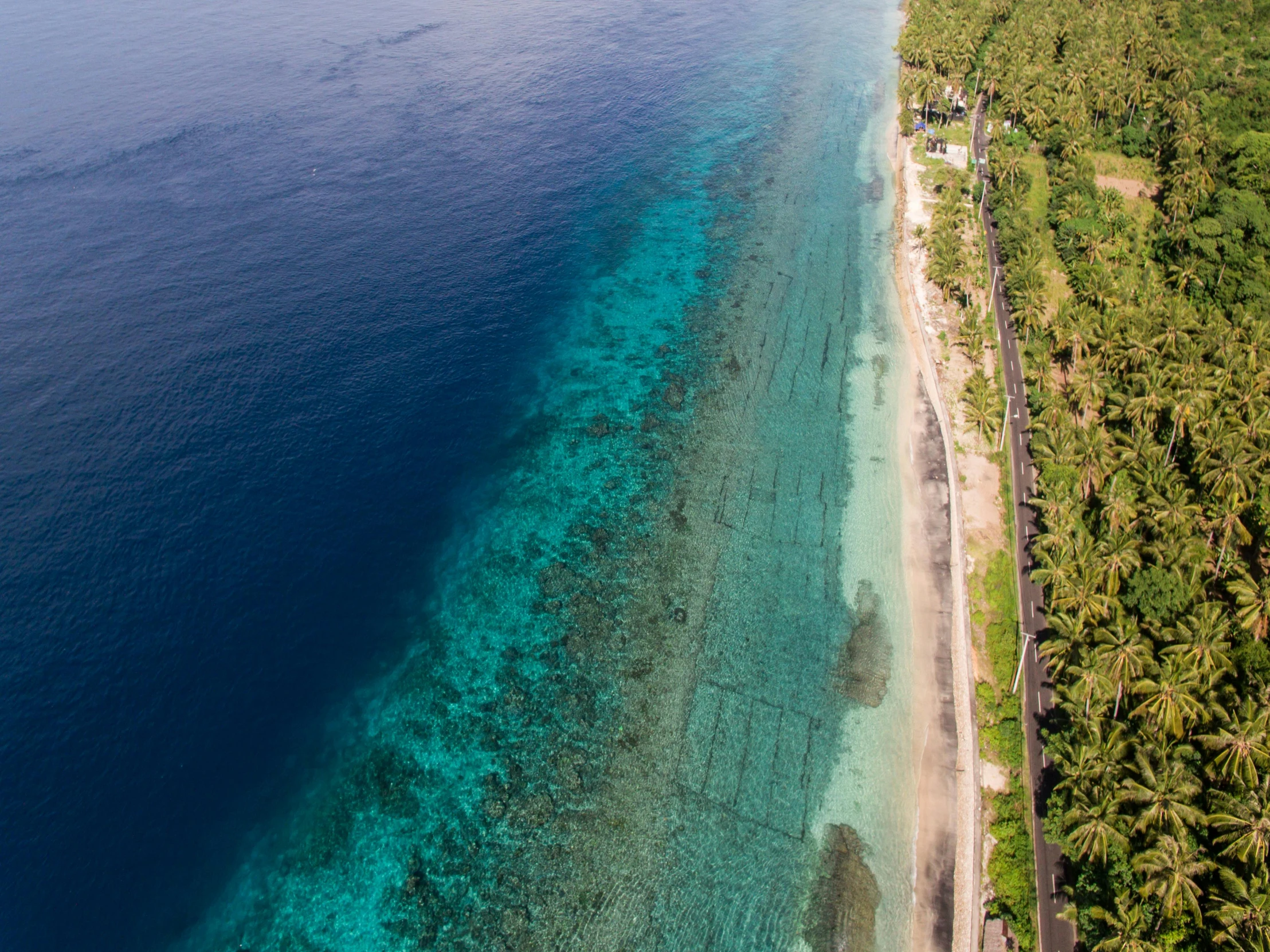 this is an aerial view of a sandy beach and clear blue water