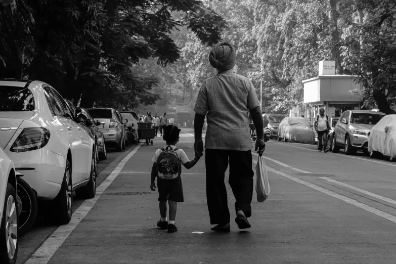 a man and a small child walking across a sidewalk