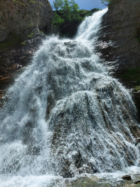 the water is flowing down from the side of the hill