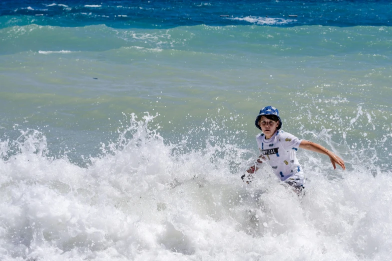 a  standing on top of a white surfboard in the ocean