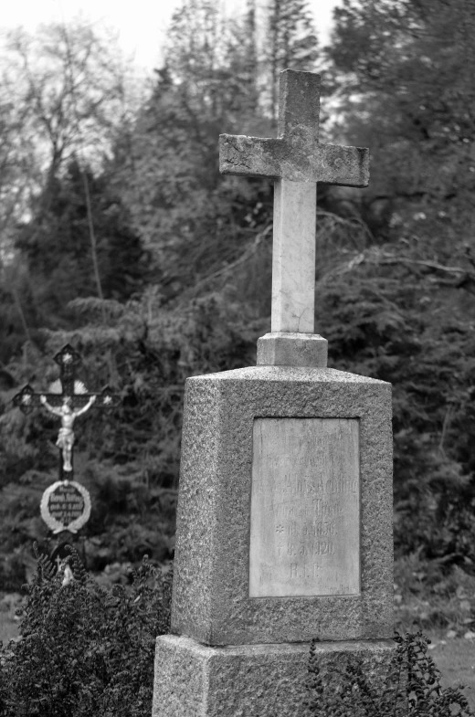 an old graveyard with cross and plaque at it