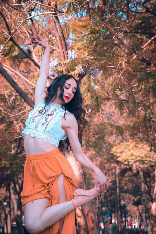 a woman standing next to a leaf filled forest