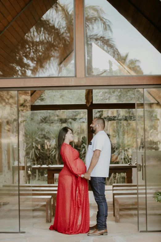 a man and woman standing in front of a window