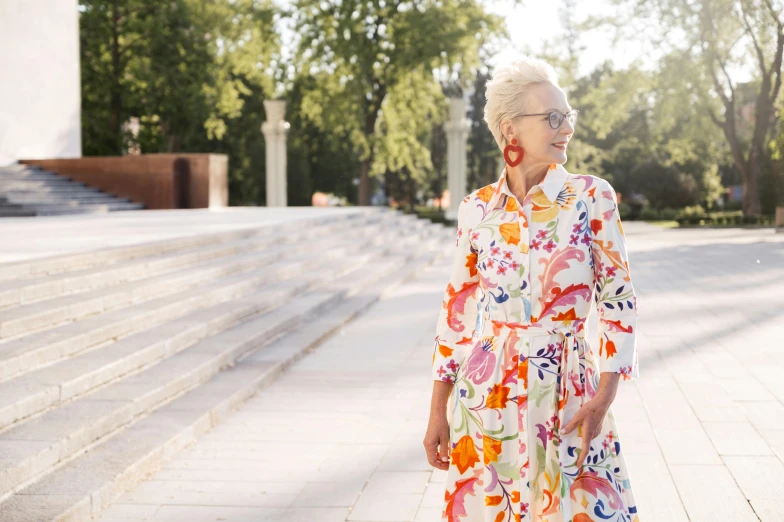 an older woman is wearing a floral print dress