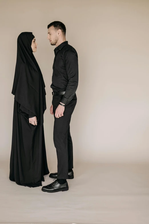 a man standing next to a woman in a black gown