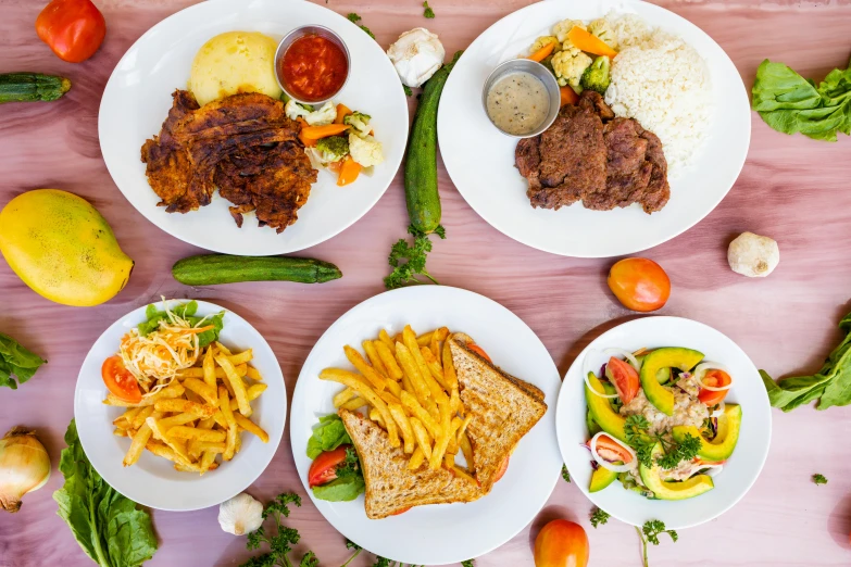 several plates of food with different types of meats and vegetables