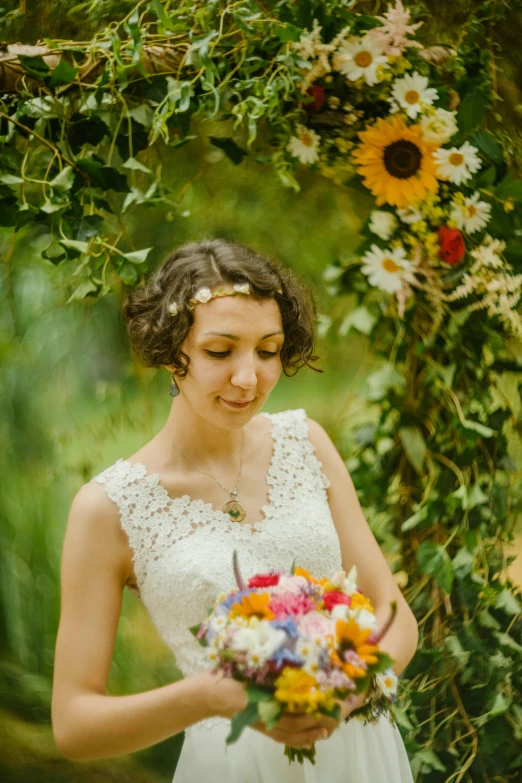 woman holding bouquet looking down and looking at flower