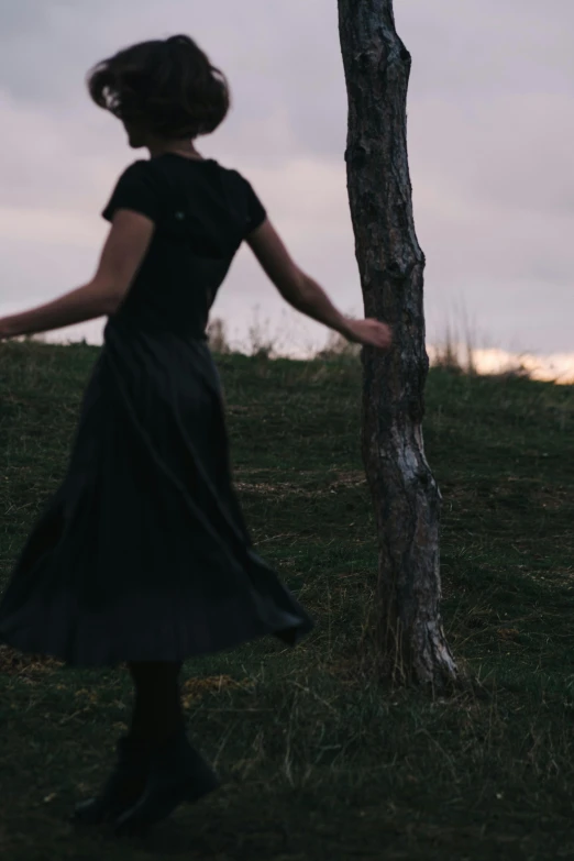 an image of woman standing by a tree