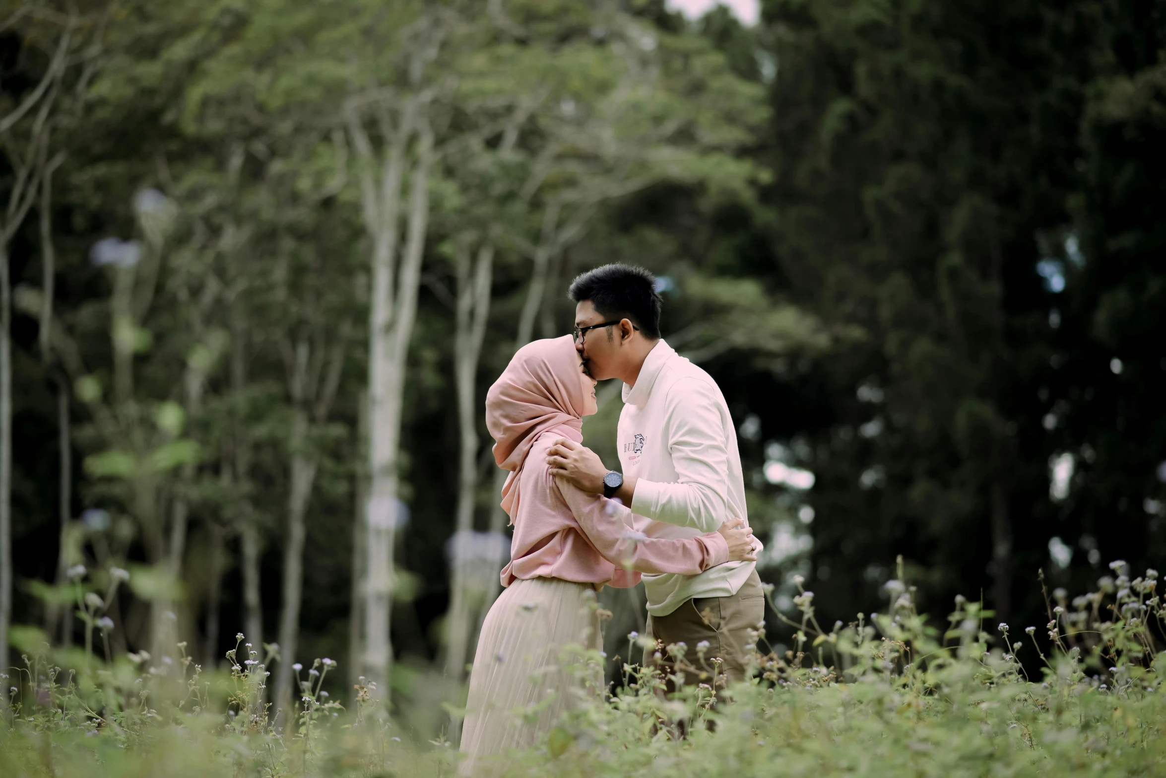 a man with a  wearing a white dress holding onto a pink and black ribbon