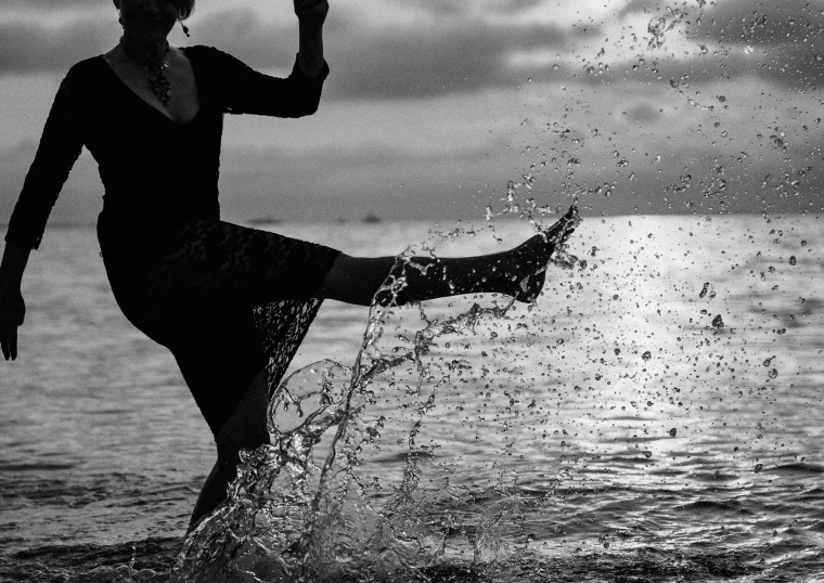 woman in black outfit splashing water on her feet