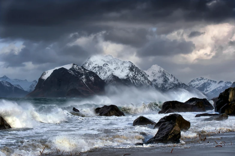 water is rushing up the shore and over the rocks