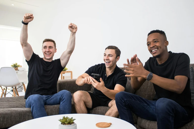 three people smiling and raising their arms in the air