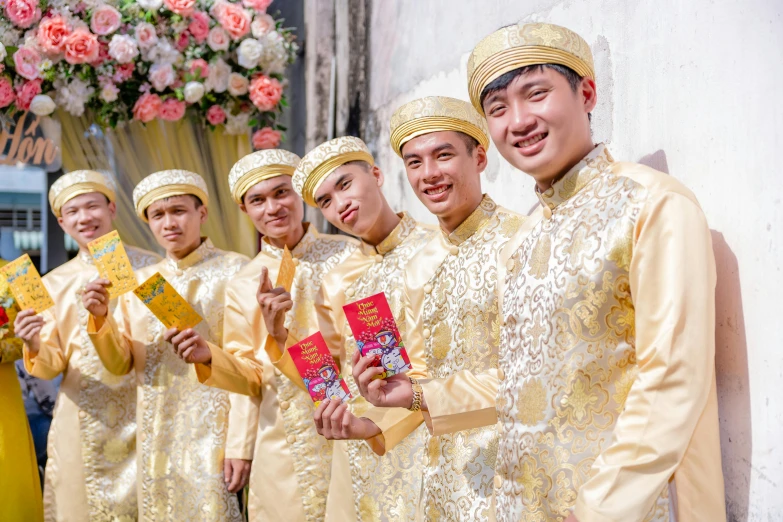 some men dressed in yellow are standing by a wall