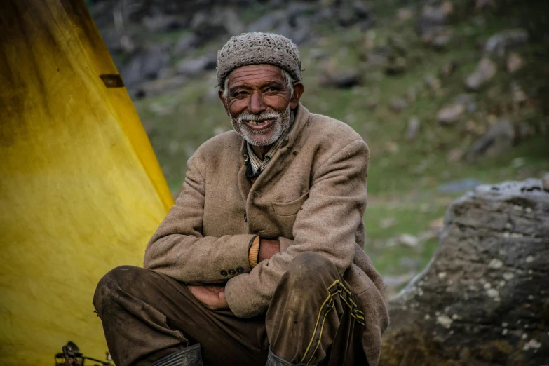 a man is sitting on the side of a yellow structure