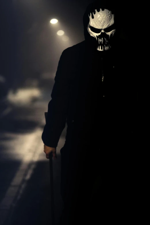 a man in a black jacket walking in the dark