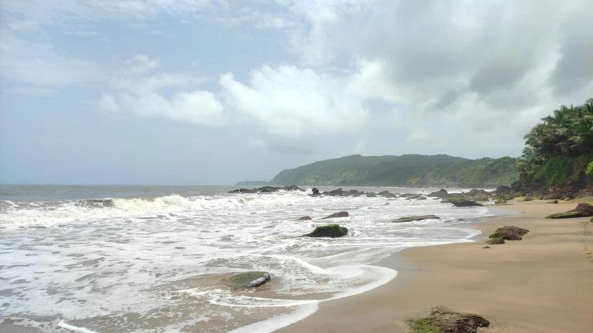 an ocean shoreline with a wave coming onto the shore