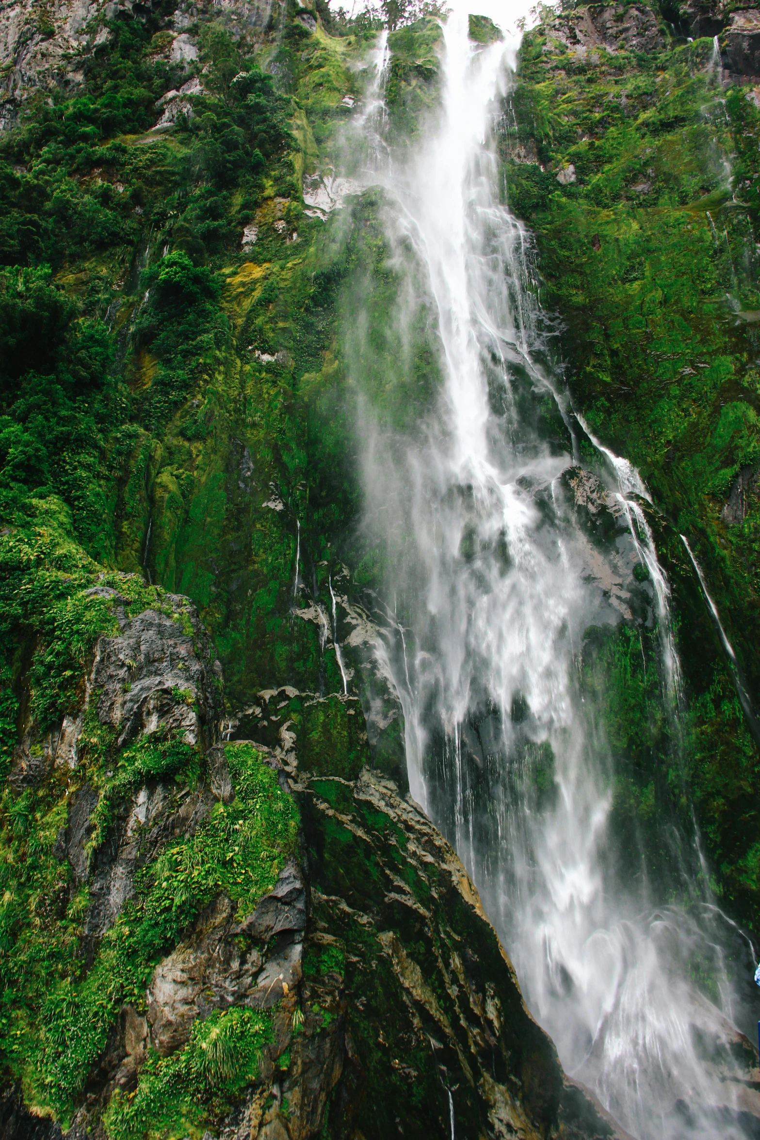 water pouring over the top of a waterfall in the forest