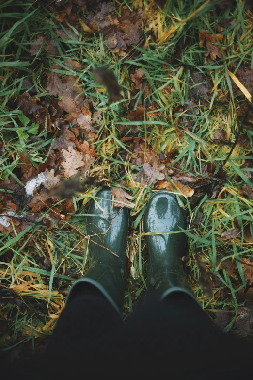 a persons feet in a pair of green rubber boots