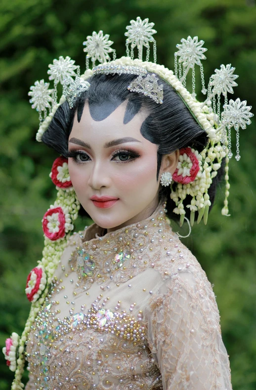 a woman in asian fashion with white flowers and an elaborate headpiece