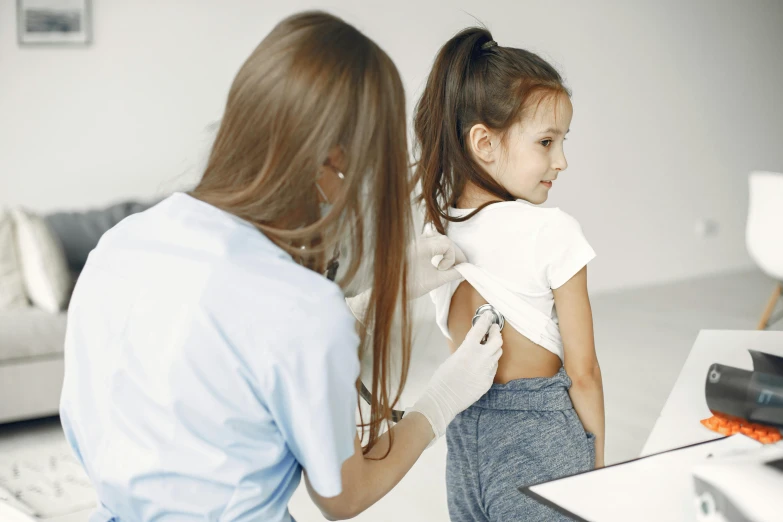 woman doing hair care for a young child in a room