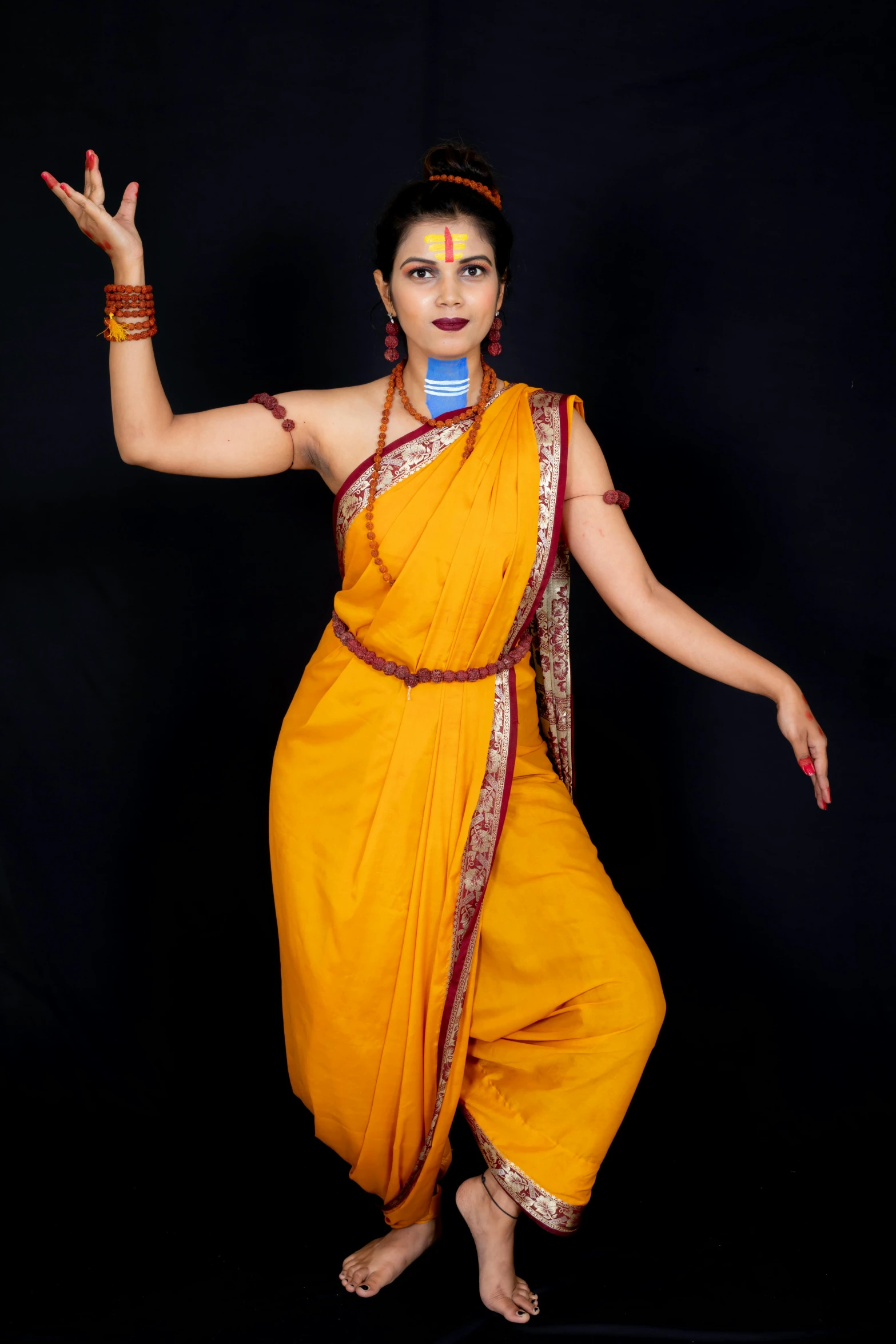 a woman in an orange sari is wearing a microphone