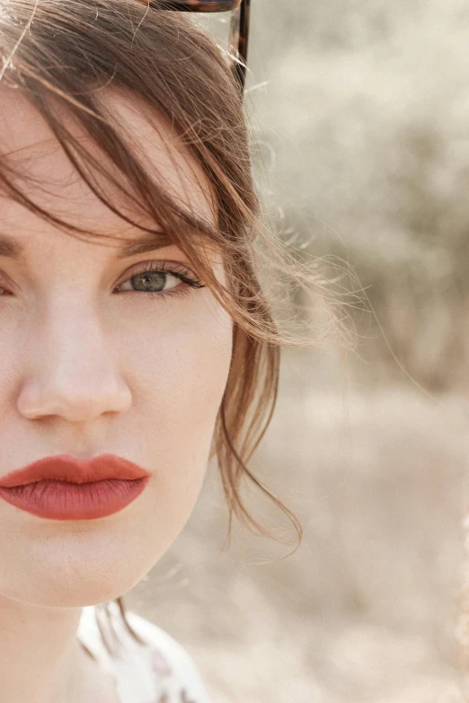 a woman with red lips wearing sunglasses is looking to the side