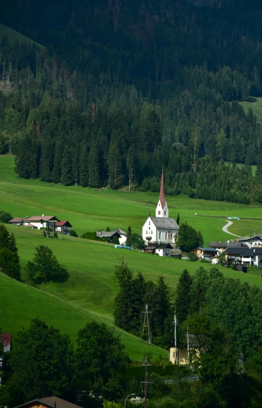 this house is next to a forest and has a small church in the front