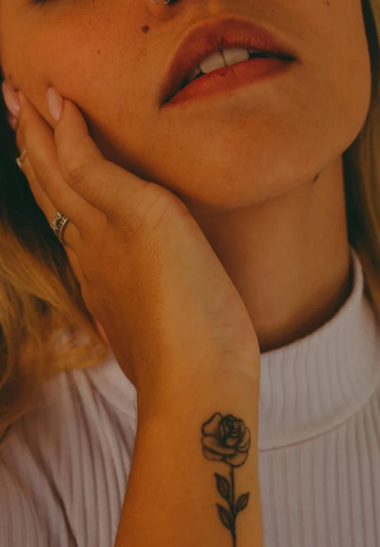 there is a woman with a rose tattooed on her arm