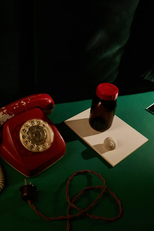 an old style red phone on a green table