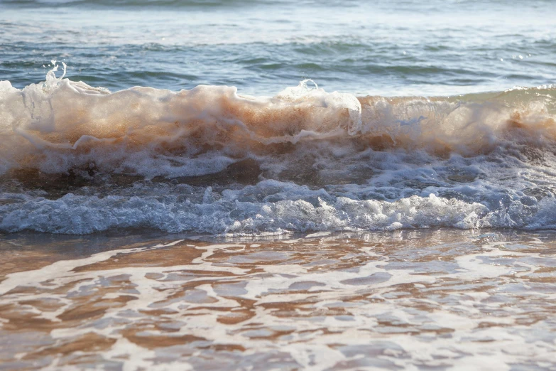 waves hitting the beach and breaking on a sunny day