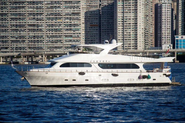 a white boat in the water near some buildings