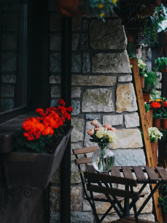 a wooden chair next to a stone building