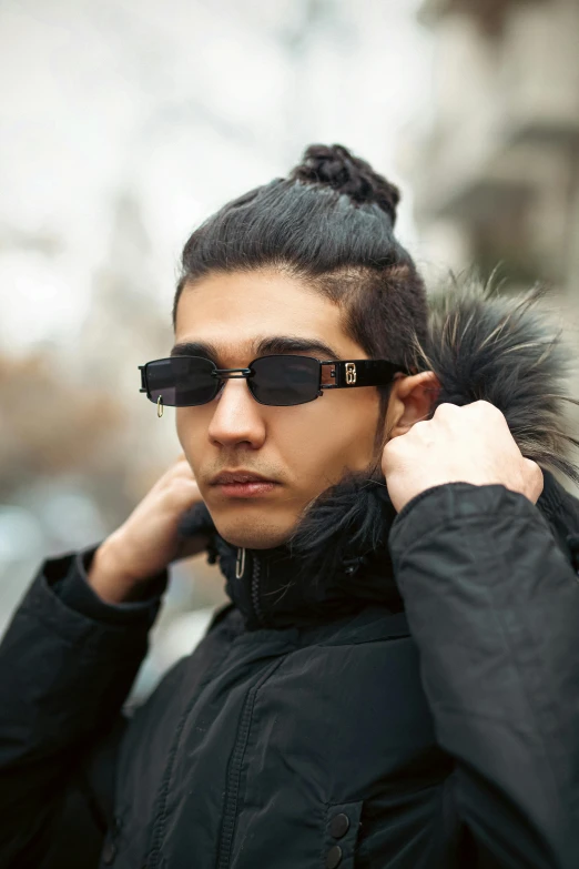 a woman with sunglasses is putting her hair up