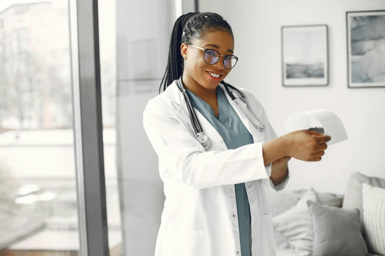 a smiling woman wearing glasses and a lab coat