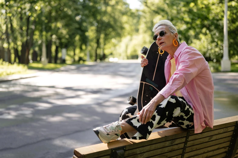 two women sit on a park bench in the sun