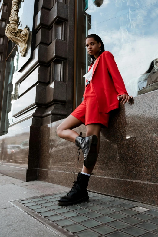 woman leaning against concrete wall wearing high heeled boots