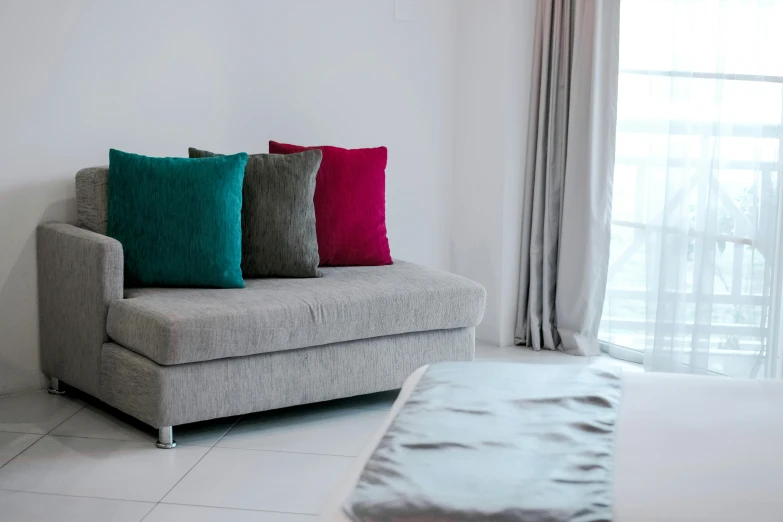 a couch sitting on top of a white floor next to a window