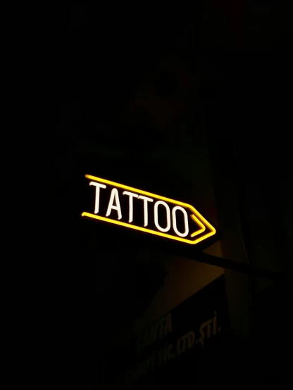 the neon tattoo sign on the dark street lights