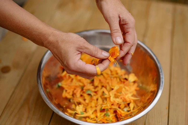 the child is peeling the slice of carrot into a bowl