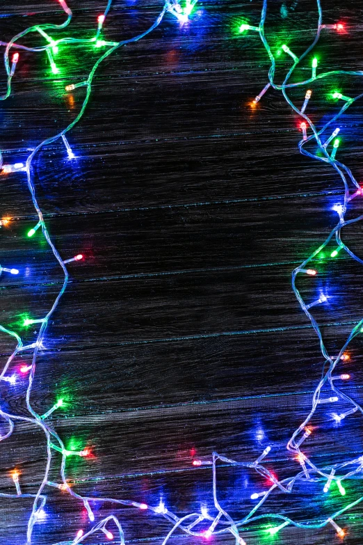 a group of stringed multicolored lights hanging on top of a black surface