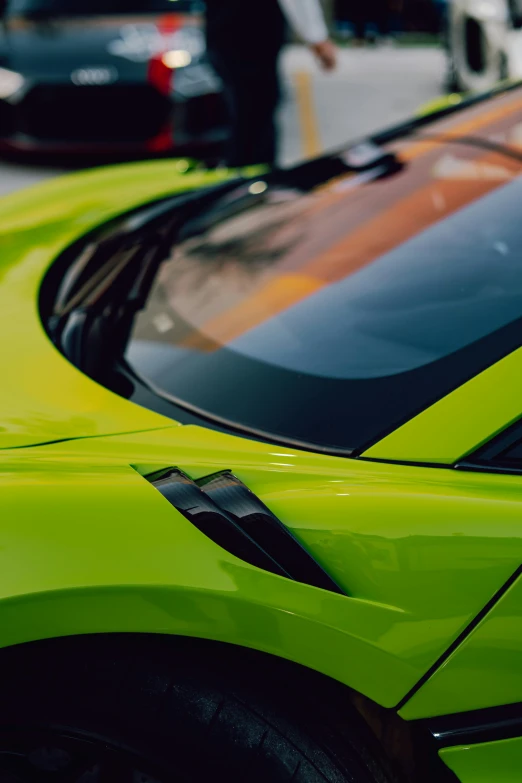 two green sports cars sit next to each other