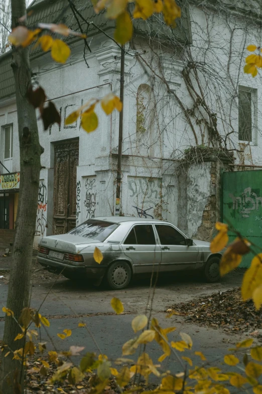 a car parked next to a building and trees