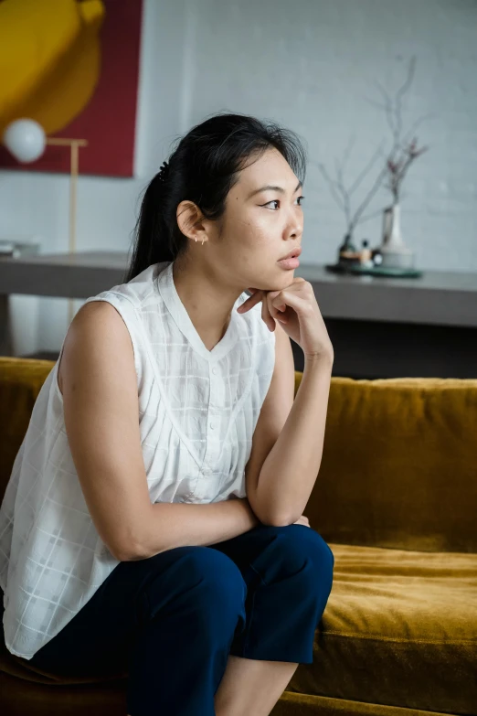 woman sitting on the couch in front of a wall