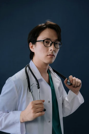 a male doctor is holding a black pen with a green tie