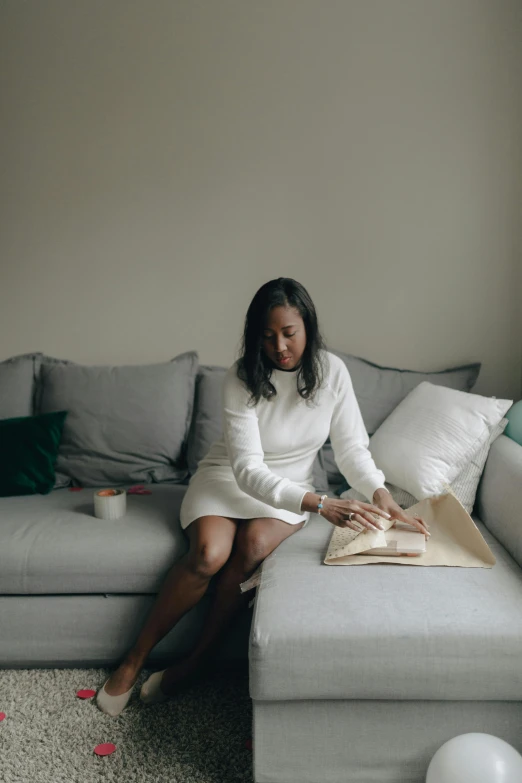 a woman sitting on top of a couch next to a pillow