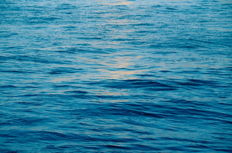 a small boat is sitting in a very large body of water