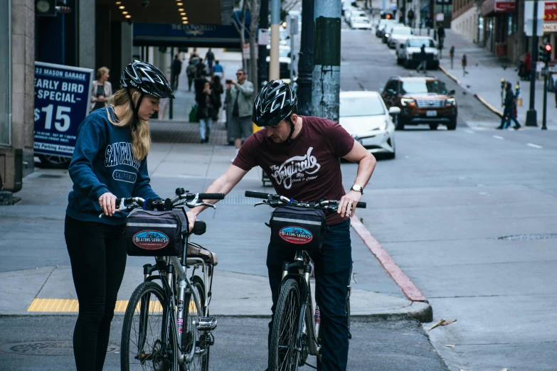 two bicyclists are on the street together, wearing helmets